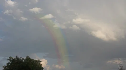 Colorful rainbow on cloudy sky in a rainy day Stock Footage 30580789