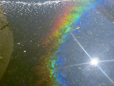 Colorful Rainbow Effect on Water Surface Caused by Oil or Fuel Spill Stock Photos