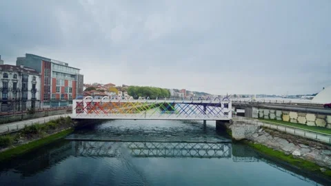 Colorful rainbow pedestrian bridge reflecting in the river water Stock Footage 336106902