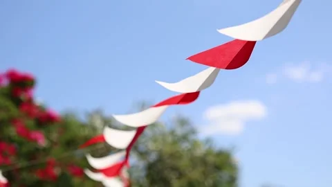 Colorful Red and White Triangular Bunting Flags Hanging Against Blue sky for Stock Footage 340960930