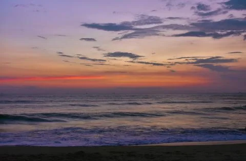 Colorful reddish sky over the horizon with layer of sand in foreground Stock Photos