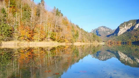 Colorful reflections on a tranquil lake surrounded by the alpine beauty of Ba Video stock 309093926