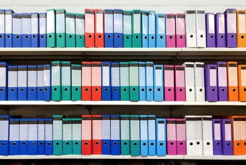 Colorful ring binder folder on white shelves, office stationary Stock Photos