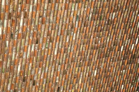 Colorful rooftop tiles create a patchwork in sunlight over a building Stock Photos