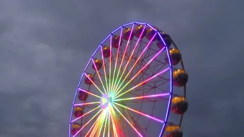 Colorful rotating nostalgic Ferris Wheel - dark cloudy sky - time lapse Stock Footage 140733675