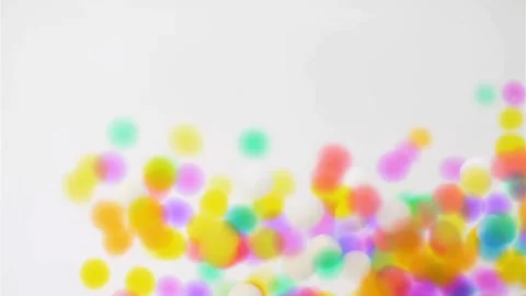 Colorful round particles dropping and covering a bright surface Stock-Footage 333834421