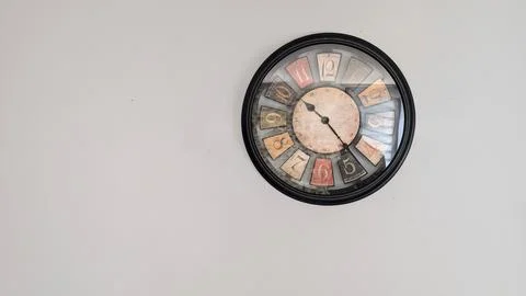 Colorful round wall clock on a plain white wall Stock Photos