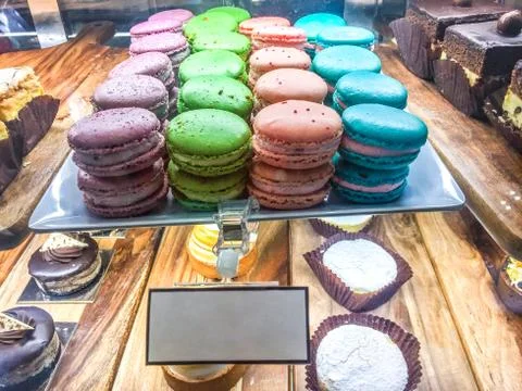 Colorful rows of macaroons in cafe storefront display window with copy space Foto stock