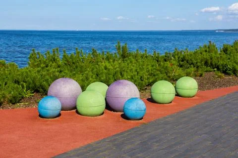 Colorful rubber sphere playground elements on seaside promenade Stock Photos