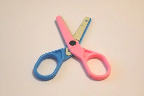 Colorful scissors crossed on a plain surface Stock Photos