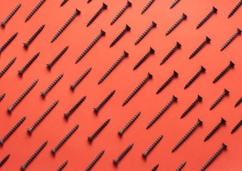 Colorful screw pattern top view on red background Stock Photos