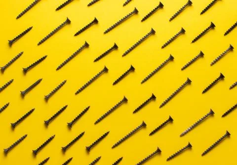 Colorful screw pattern top view on yellow background Stock Photos