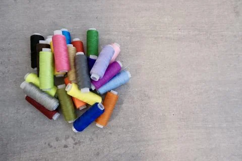 Colorful Sewing Thread Spools Flat Lay on Concrete Background Stock-Fotos