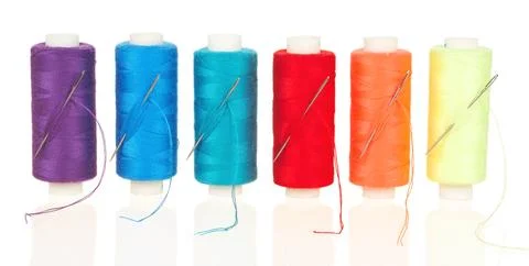 Colorful Sewing Thread Spools with Needles Isolated on White Background Stock Photos