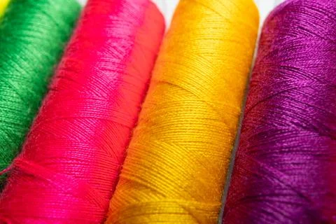 Colorful sewing thread spools in a row close up macro concept for textile Stock Photos