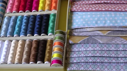 Colorful sewing threads and designed fabric patterns in tailor shop Stock Footage 132363254