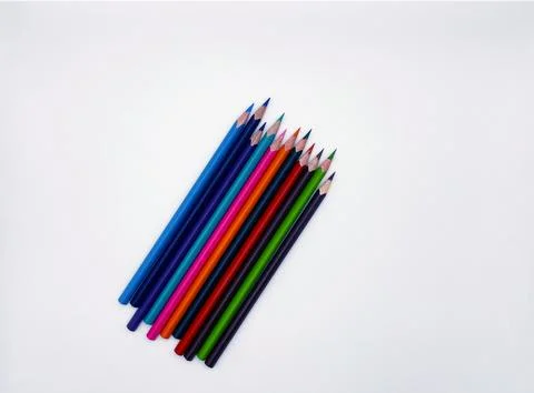 Colorful sharpened pencils are lined up on the table. Stock Photos
