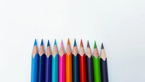 Colorful sharpened pencils are lined up on the table. Stock Photos