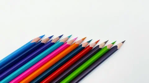 Colorful sharpened pencils are lined up on the table. Stock Photos