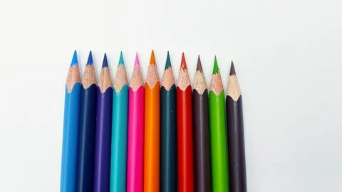 Colorful sharpened pencils are lined up on the table. Stock Photos
