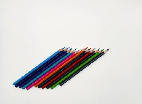 Colorful sharpened pencils are lined up on the table. Stock Photos