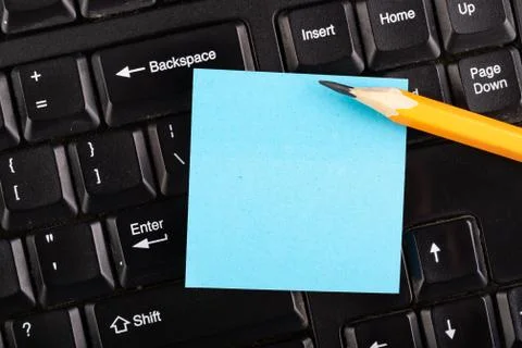 A colorful sheet of notes on a computer keyboard. Place for notes at the comp Stock Photos