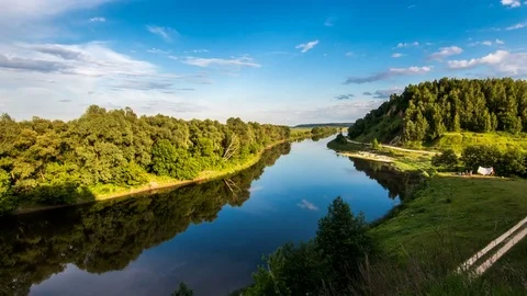 Colorful sky, clouds over the river between the forest and the field 動画素材 77267434