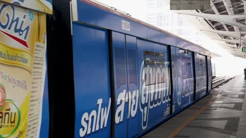 Colorful Skytrain Departing Elevated Urban Station in Bangkok Stock Footage 323679748