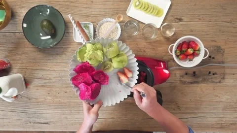 A colorful smoothie-making process using fresh fruits like dragon fruit, kiwi Stock Footage 303061277