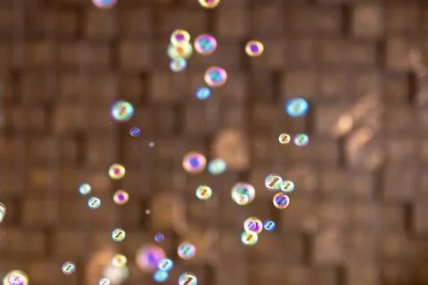 Colorful soap bubbles floating on warm brown background. Iridescent abstrac.. Stock Photos