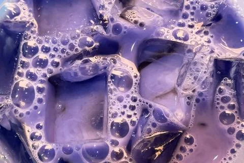 Colorful soapy liquid with bubbles closeup, cloudy water texture Stock Photos
