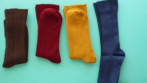 Colorful sock collection displayed on a blue surface Stock Footage 320920599