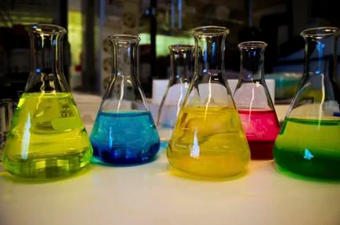 Colorful solution composition of conical flask lined on a bench in a chemistr Stock Photos
