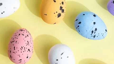 Colorful speckled easter eggs on soft yellow background 動画素材 347736829