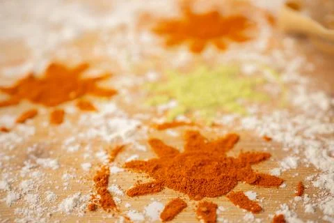 Colorful spice patterns resembling sun shapes created with red and green po.. Stock Photos