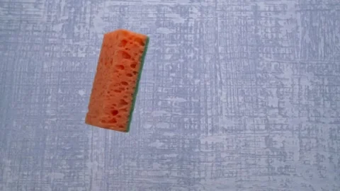 A Colorful Sponge Placed on a Textured Surface, Ideal for Cleaning and Household Видео 291422404