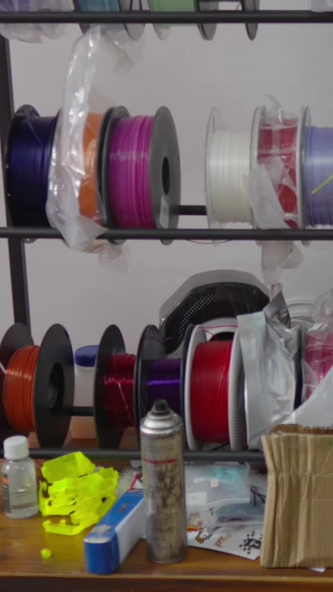 Colorful spools of 3D printer filament stored on shelves in a workshop. Plastic Stock Footage 328988259