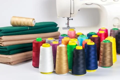 Colorful spools of thread and fabric ready for sewing in craft studio Stock-Fotos