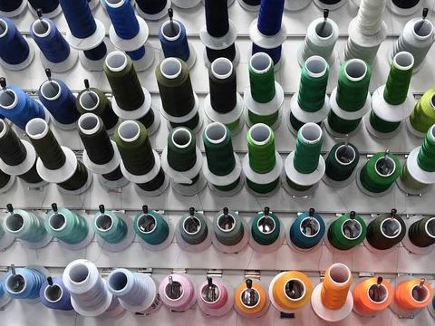 Colorful spools of thread are attached to the wall. Stock Photos