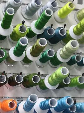 Colorful spools of thread are attached to the wall. Stock Photos