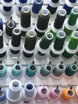 Colorful spools of thread are attached to the wall. Stock Photos