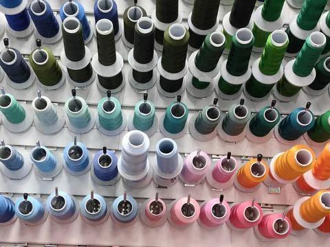 Colorful spools of thread are attached to the wall. Stock Photos