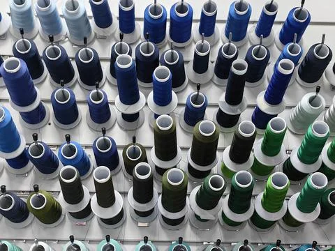 Colorful spools of thread are attached to the wall. Stock-Fotos