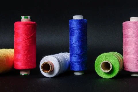 Colorful spools of thread on black background 写真素材