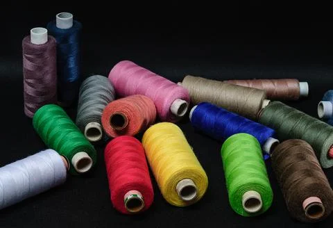 Colorful spools of thread on black background Foto stock