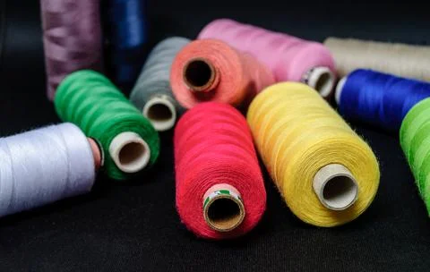 Colorful spools of thread on black background Stock Photos
