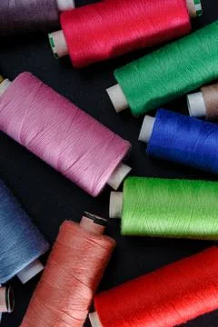 Colorful spools of thread on black background 写真素材