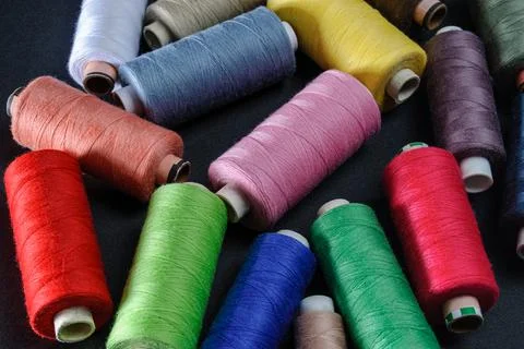 Colorful spools of thread on black background Foto stock