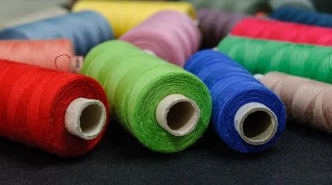 Colorful spools of thread on black background Stock Photos
