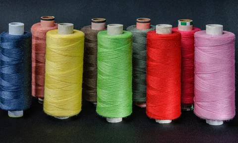 Colorful spools of thread on black background Stock Photos